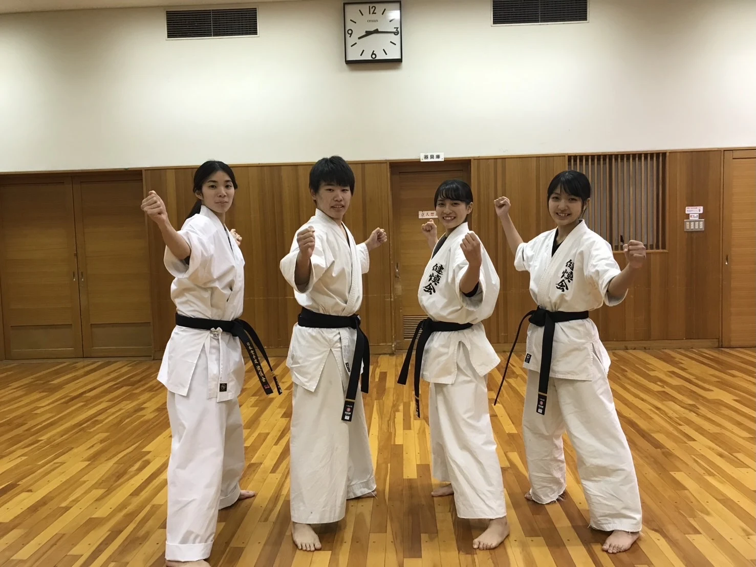 黒帯4人でポーズをとる稽古生たち
